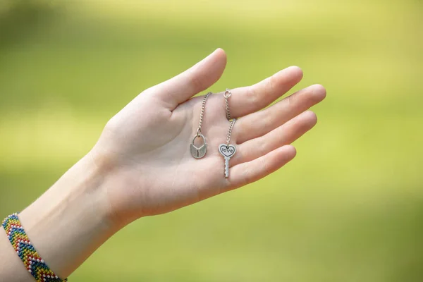 Weibliche Hand Mit Silberner Kette Mit Schlüssel Und Herz Weibliche — Stockfoto