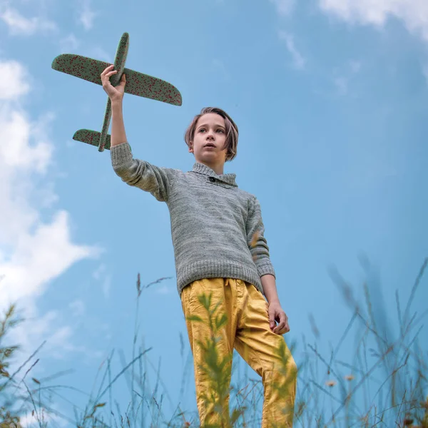 Αγόρι Κρατώντας Ένα Αεροπλάνο Στο Χέρι Του Ενάντια Στον Γαλάζιο — Φωτογραφία Αρχείου