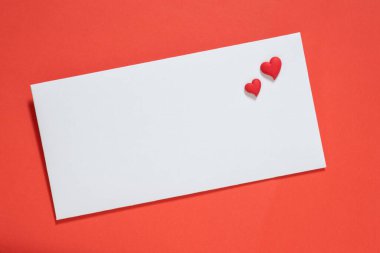 Kırmızı arka planda beyaz bir zarf, birbirine aşık bir çiftin iki küçük kalp sembolü, tasarımın temeli, serbest alan