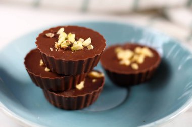 Sütlü çikolata Kupası candys mavi plaka üzerinde fıstıklı