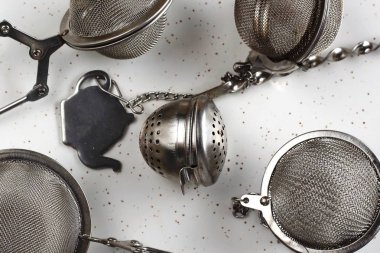Metal çay süzgeçler ile epty yer beyaz arka plan üzerinde