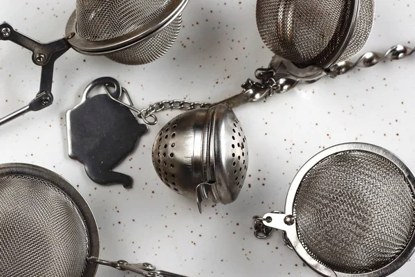 Metal çay süzgeçler ile epty yer beyaz arka plan üzerinde