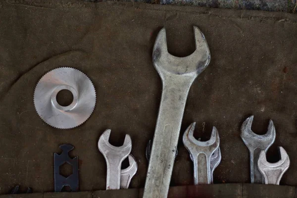 Wrench old retro tool kit on the dark brown gloomy  fabric texture