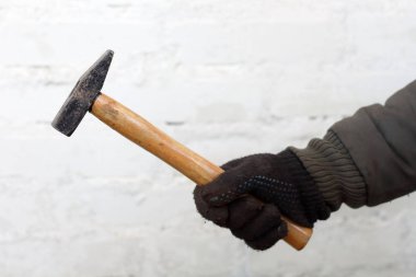 Beyaz arka plan yakın çekim siyah eldiven çalışan adam elinde ahşap saplı çekiç