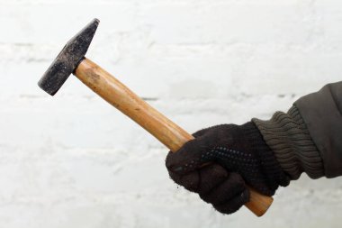 Beyaz arka plan yakın çekim siyah eldiven çalışan adam elinde ahşap saplı çekiç