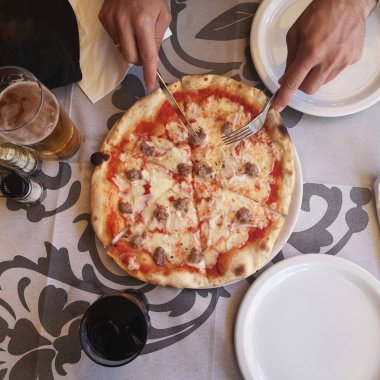 Güneşli bir yaz aylarında bir kafede iki kişilik pizza ve içecekler ile bir tabloda üstten görünüm