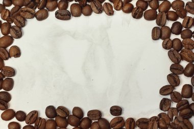 Koyu kavrulmuş kahve çekirdekleri ile mermer doku kopya alanı için metin çerçevesi