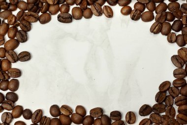 Koyu kavrulmuş kahve çekirdekleri ile mermer doku kopya alanı için metin çerçevesi