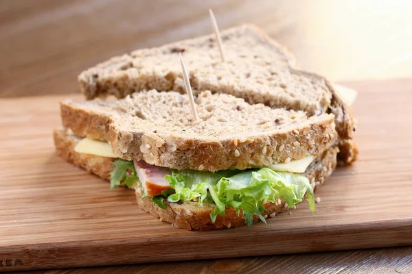 自然のグリーン サラダ レタス チーズとハムがおいしいサンドイッチは 全粒粉パン木製基板昼食のための健康的なおやつとして — ストック写真
