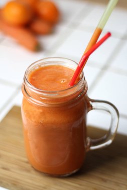 Saydam bir cam tübüllerin tarafından gün sağlıklı beslenme beyaz bir tablo ile turuncu sağlıklı serinletici vejetaryen havuç yüzlü detoks diyet