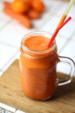 Saydam bir cam tübüllerin tarafından gün sağlıklı beslenme beyaz bir tablo ile turuncu sağlıklı serinletici vejetaryen havuç yüzlü detoks diyet