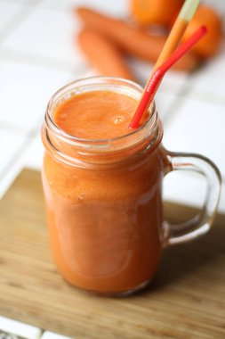 Saydam bir cam tübüllerin tarafından gün sağlıklı beslenme beyaz bir tablo ile turuncu sağlıklı serinletici vejetaryen havuç yüzlü detoks diyet