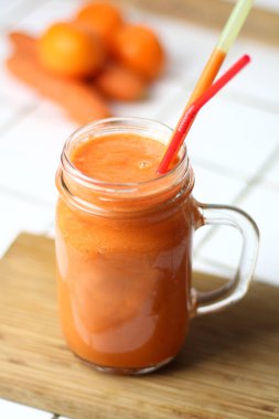 Saydam bir cam tübüllerin tarafından gün sağlıklı beslenme beyaz bir tablo ile turuncu sağlıklı serinletici vejetaryen havuç yüzlü detoks diyet