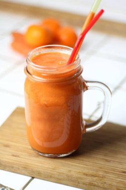 Saydam bir cam tübüllerin tarafından gün sağlıklı beslenme beyaz bir tablo ile turuncu sağlıklı serinletici vejetaryen havuç yüzlü detoks diyet