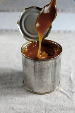 Ev yapımı geleneksel bir kaşık gelen masaya döktü bir teneke içinde yoğunlaştırılmış süt haşlanmış