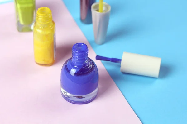 Colorful nail lacquer  polish bottle and nail brushes on pink background.  Nail service manicure