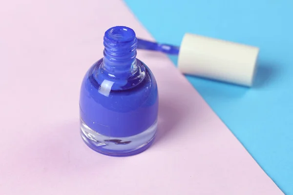 Blue nail lacquer  polish bottle and nail brushes on pink background.  Nail service manicure