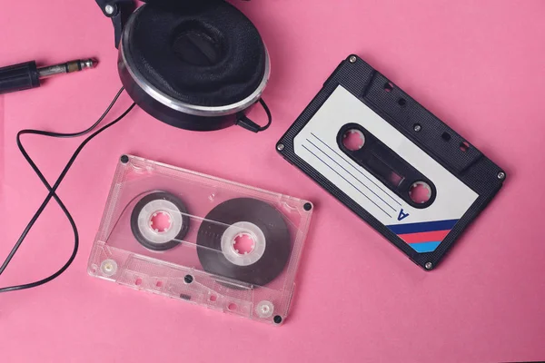 组两个音频复古复古卡塞特磁带和耳机80年代风格的粉红色背景 — 图库照片
