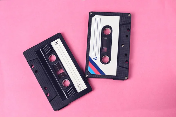 group of two audio retro vintage cassete tape 80s style on pink background