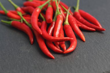 Tazelik su çiğ siyah grafit kayrak taş yüzeyi, keskin sıcak baharat kırmızı biber biber ile ıslak bir sürü bırakır. Doğal vejeteryan diyet organik sebze. Karanlık gıda foto