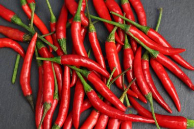 Tazelik su çiğ siyah grafit kayrak taş yüzeyi, keskin sıcak baharat kırmızı biber biber ile ıslak bir sürü bırakır. Doğal vejeteryan diyet organik sebze. Karanlık gıda foto