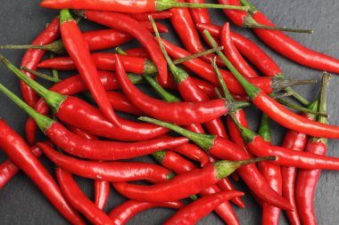 Tazelik su çiğ siyah grafit kayrak taş yüzeyi, keskin sıcak baharat kırmızı biber biber ile ıslak bir sürü bırakır. Doğal vejeteryan diyet organik sebze. Karanlık gıda foto