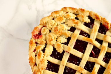 Rozet ve doug yaprakları bir Mermer yüzey üzerinde klasik eski stil ev yapımı Amerikan vişneli tart üst bir kafes ile süslenmiş