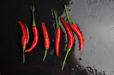 Tazelik su çiğ bir siyah grafit kayrak taş yüzeye düzenlenmiş doğrultusunda, keskin sıcak baharat kırmızı biber biber ile ıslak bir sürü bırakır. Doğal vejeteryan diyet organik sebze