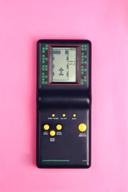 Pembe bir arka plan retro ve grup 80s ve 90s tarzı çocukluk oyundan sarı düğmeleri ile siyah tetris oyun konsolu