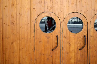 Ahşap kapı girişi. Denizcilik tarzında. Eski bir gemi teknesinde pencere var.