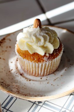Ev yapımı ekmek stil vanilya lezzetli kek krem beyaz tereyağı krema buzlanma ve badem üstte. Şahsın ve doğum günü kutlamak için çikolata