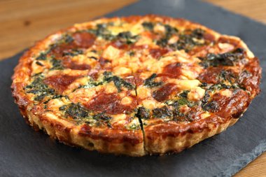 Peynir, ıspanak ve siyah bir tabakta domates İtalyan geleneksel rustik kiş pizza