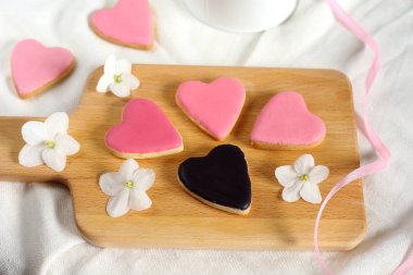 Oldukça kızlara özgü düz ile hafifçe pembe kalpler çerezleri yatıyordu ve 1 siyah kalp kurabiye beyaz menekşeler çiçek açan çiçekler ve saten ribbon.14 Şubat Sevgililer günü ve düğün bonboniers hediye ile tedavi