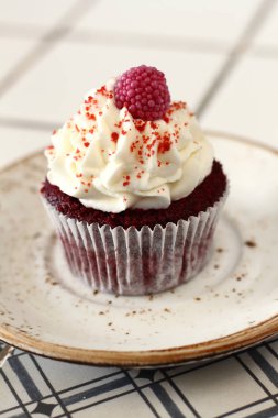 Ev yapımı ekmek stil kırmızı kadife lezzetli sünger kek ile beyaz tereyağı krema buzlanma ve raspberrie üst plaka üzerinde. Şahsın ve doğum günü kutlamak için çikolata