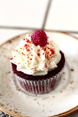 Beyaz tereyağı krema buzlanma ve raspberrie plaka ile lezzetli kırmızı kadife lezzetli sünger kek. Şahsın ve doğum günü kutlamak için çikolata