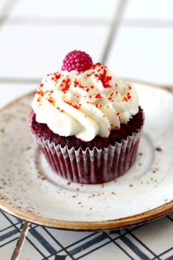 Ev yapımı ekmek stil kırmızı kadife lezzetli sünger kek ile beyaz tereyağı krema buzlanma ve raspberrie üst plaka üzerinde. Şahsın ve doğum günü kutlamak için çikolata