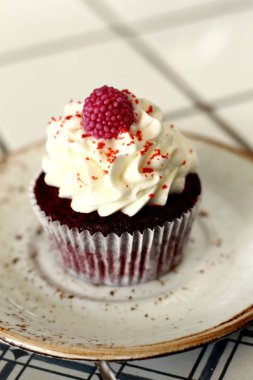 Ev yapımı ekmek stil kırmızı kadife lezzetli sünger kek ile beyaz tereyağı krema buzlanma ve raspberrie üst plaka üzerinde. Şahsın ve doğum günü kutlamak için çikolata