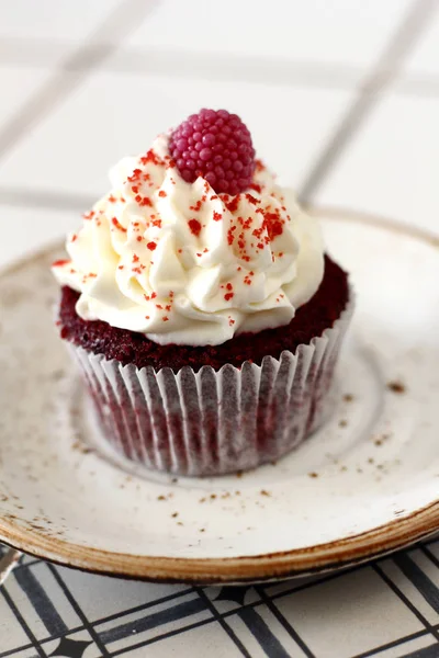 Ev yapımı ekmek stil kırmızı kadife lezzetli sünger kek ile beyaz tereyağı krema buzlanma ve raspberrie üst plaka üzerinde. Şahsın ve doğum günü kutlamak için çikolata