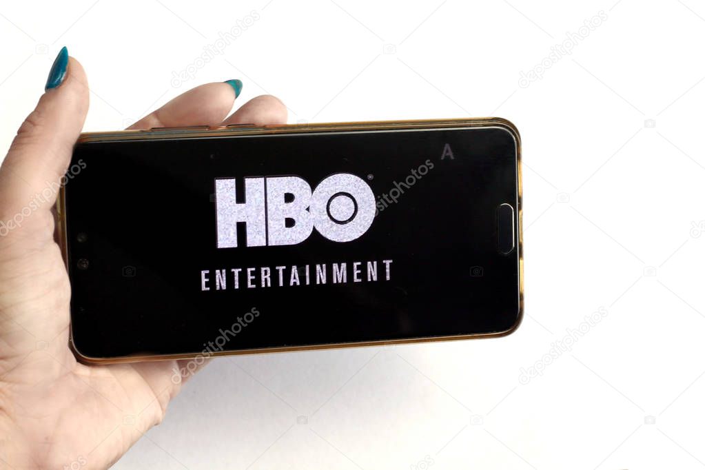 Saint-Petersburg, Russia, March 26:  Female hands holding a smartphone with HBO logo before the show on display screen, watching a hbo streaming service on mobile phone, llustrative Editorial