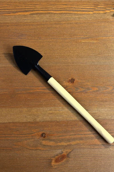 Shovel  for garden work  with wooden handle on wooden background