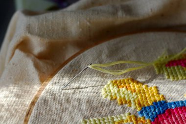 Dikiş iğne ve iplik ile tuval üzerine çapraz. Nakış işlemi ve dikiş aksesuarları.