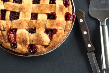 Pasta için kolu ve kepçe ile bıçak ile siyah bir grafit arka planda hamur bir kafes ile geleneksel lezzetli kiraz pastası. Tatil Treat eski moda Retro Amerikan tatlı Pie