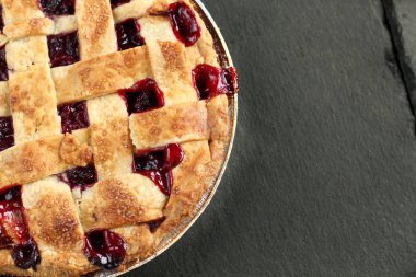 Metin için boş alan ile siyah bir grafit arka planda hamur bir kafes ile geleneksel lezzetli kiraz pastası. Tatil tedavisi