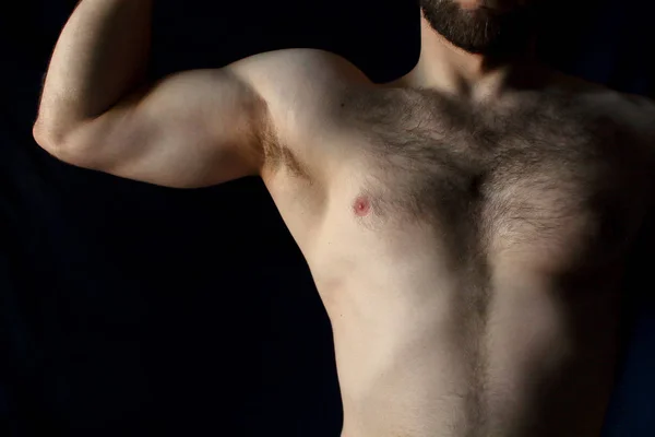 一个运动的人的残酷的肌肉健身运动员的躯干与毛茸茸的胸部对黑色背景 — 图库照片
