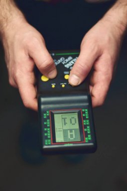 Saint-Petersburg, Rusya, Mart 27: Adam elleri tutan ve siyah retro elektronik taşınabilir oyun konsolu tetris, açıklayıcı Editoryal oynuyor