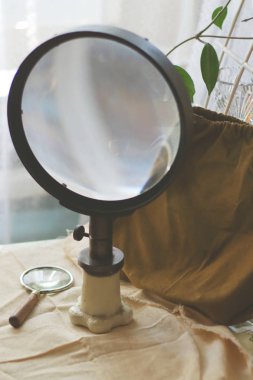 Tuval kumaş üzerinde büyük ve küçük vintage eski optik büyüteç camları. Bilim arama konsepti