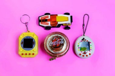 Saint-Petersburg, Rusya - 27 Mart 2019: Eski retro oyun tamagotchi sanal evcil hayvan oyuncak ve yo yo oyuncak etiket coca-cola pembe arka plan, araba 80s tarzı, 90s oyuncaklar. açıklayıcı Editoryal