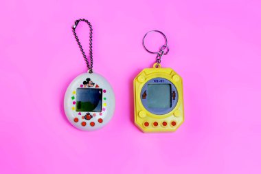 Saint-Petersburg, Rusya - 27 Mart 2019: Pembe arka planda eski retro oyun tamagotchi, 90'lardan sanal evcil hayvan oyuncağı. açıklayıcı Editoryal