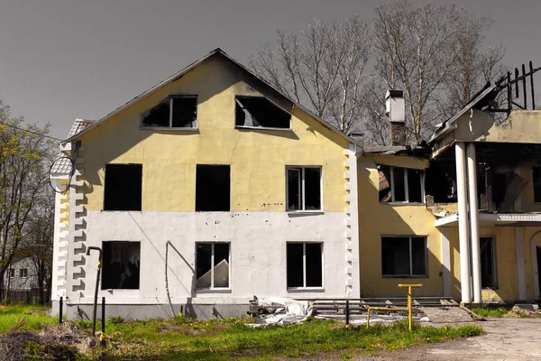 Burnt down after fire large country house with a collapsed damaged roof against a grey sky. burnt down large country house with a collapsed damaged roof against a grey sky