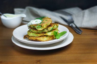Doğru beslenme, vejetaryen kahvaltı glutensiz, fasulye ile kabak kabak krep, ekşi yunan yougurt ile beyaz tabaklarda nane, siyah arka plan, havlu, çatal, ahşap yüzeyüzerinde bıçak